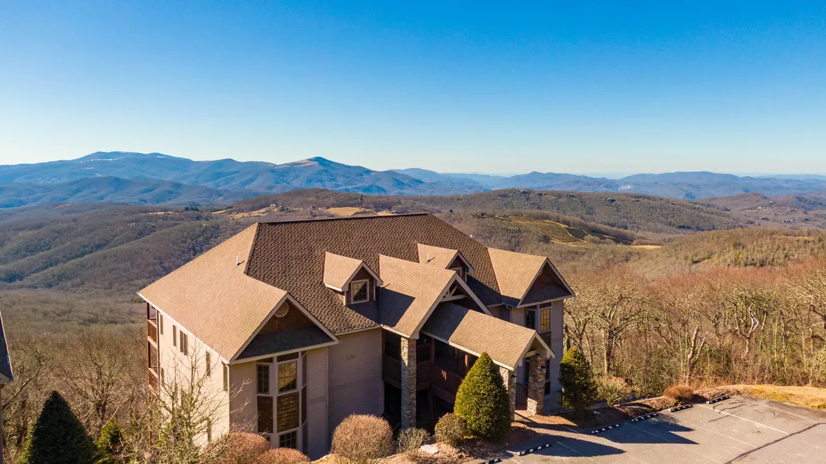 This exterior image showcases the architectural design of the house with its deck overlooking stunning mountain vistas. The landscaped surroundings invite guests to step outside and connect with nature, while the tranquil mood hints at peaceful mornings and evenings spent outdoors. Activities like enjoying sunset views on the terrace and the breathtaking sunrise are clearly depicted.
